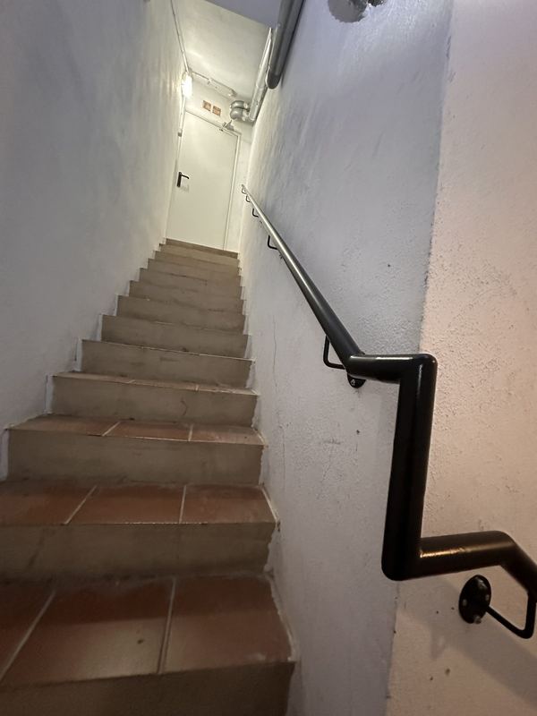 Pasamanos pintado en negro con giro en la escalera del parking